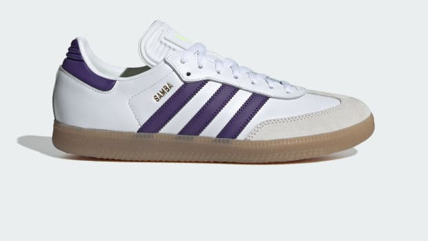 Side view of Lionel Messi's white and purple adidas Samba sneakers.